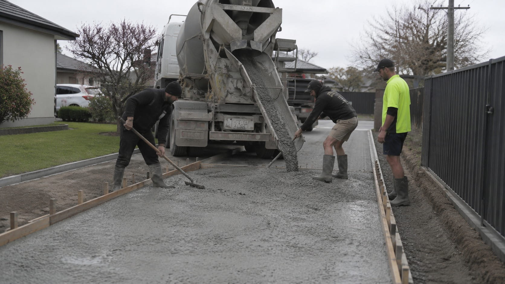 Concrete driveway pour beside a kerb and fence line in Wellington